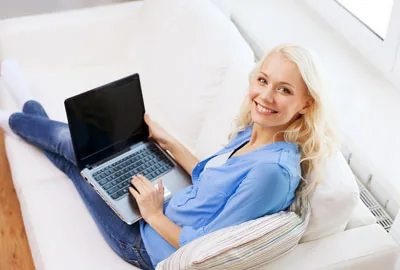 Frau mit Notebook auf einem Sofa